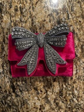 Kurt Geiger London Small Shoreditch Bow clutch in pink velvet.